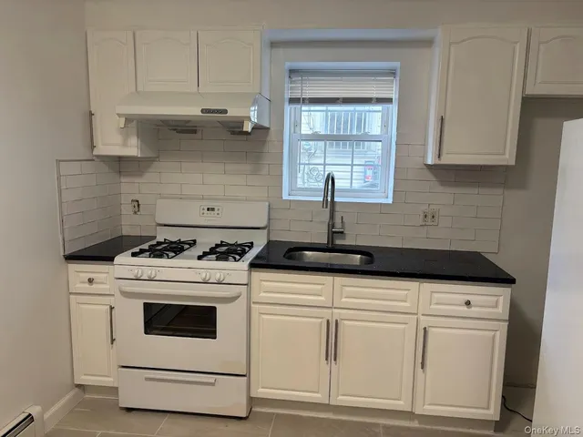 a kitchen with white cabinets and white appliances