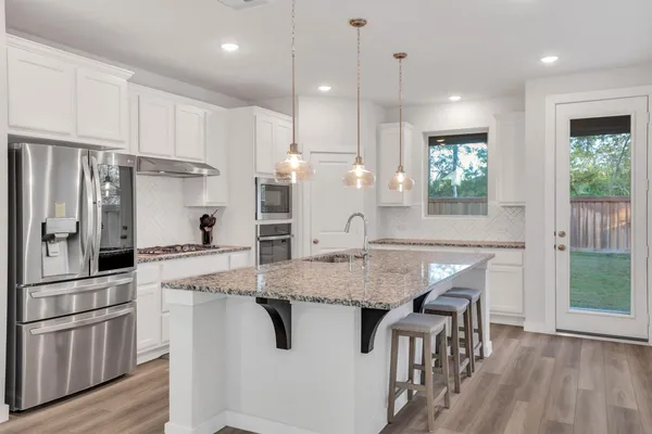 a kitchen with stainless steel appliances granite countertop a stove and a refrigerator