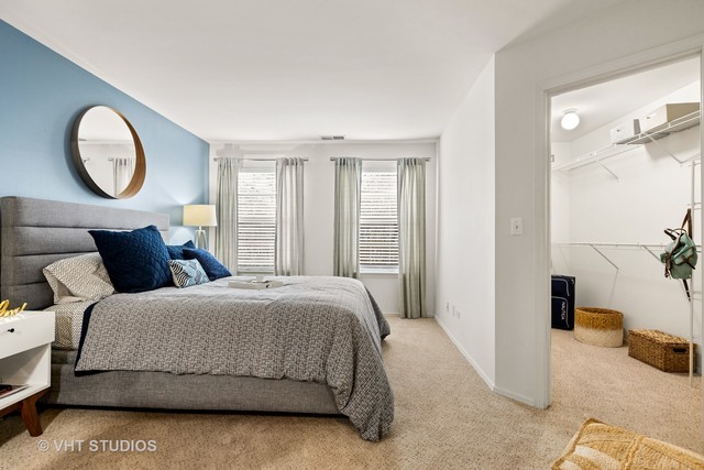 1630 Buttonwood Circle, Unit 3215 Schaumburg, IL 60173 - Photo 11 of 29 a bedroom with a bed a mirror and a window