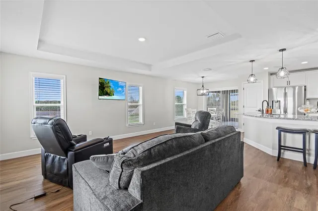 a living room with furniture and a wooden floor