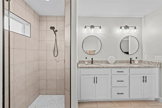 a bathroom with double granite countertop toilet a sink a mirror and vanity