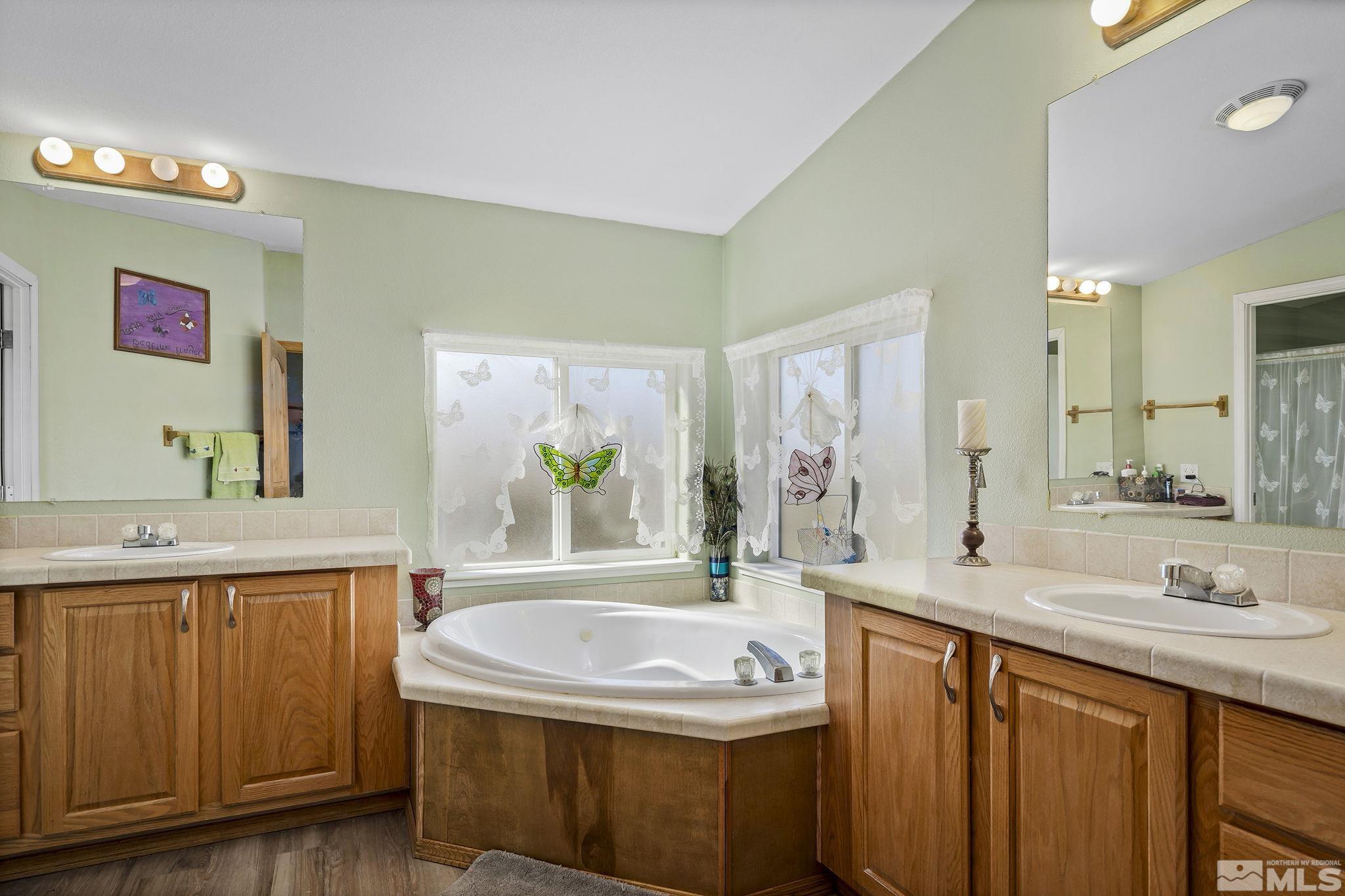3880 Tree Farm Court Reno, NV 89510 - Photo 9 of 36 a bathroom with a granite countertop sink a large mirror and a bathtub