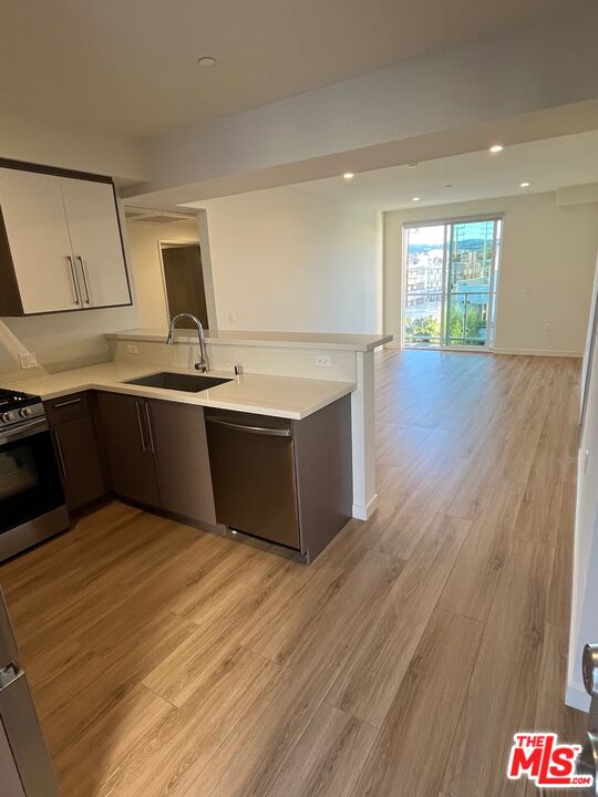 1301 South Westgate Avenue, Unit 302 Los Angeles, CA 90025 - Photo 2 of 12 a kitchen with stainless steel appliances granite countertop a sink and a wooden cabinets