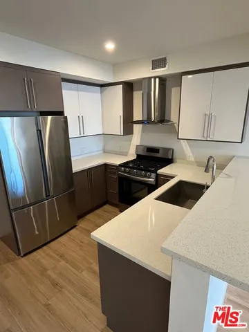 a kitchen with stainless steel appliances a refrigerator sink and stove