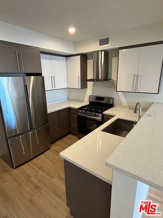 1301 South Westgate Avenue, Unit 302 Los Angeles, CA 90025 - Photo 3 of 12 a kitchen with stainless steel appliances a refrigerator sink and stove