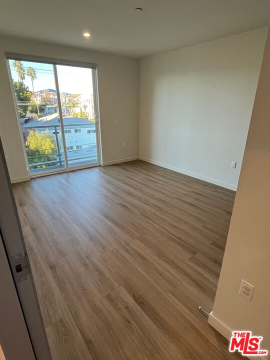 1301 South Westgate Avenue, Unit 302 Los Angeles, CA 90025 - Photo 5 of 12 an empty room with wooden floor and windows