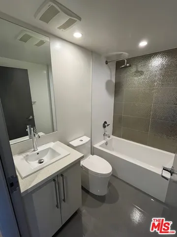 a bathroom with a double vanity sink toilet mirror and bathtub