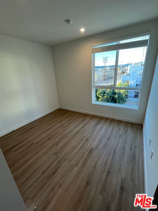 1301 South Westgate Avenue, Unit 302 Los Angeles, CA 90025 - Photo 9 of 12 an empty room with wooden floor and windows