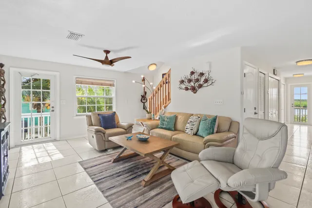 a living room with furniture a floor to ceiling window and a flat screen tv