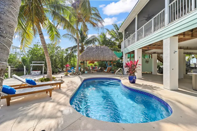 a view of a house with swimming pool and sitting area