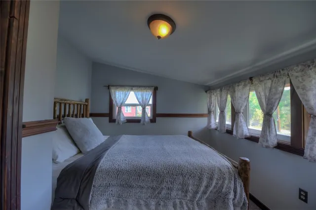 a front view of a house with yard balcony and trees