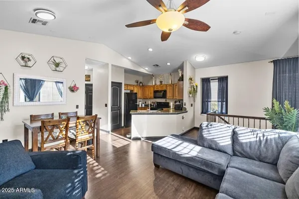 a living room with furniture kitchen view and a chandelier