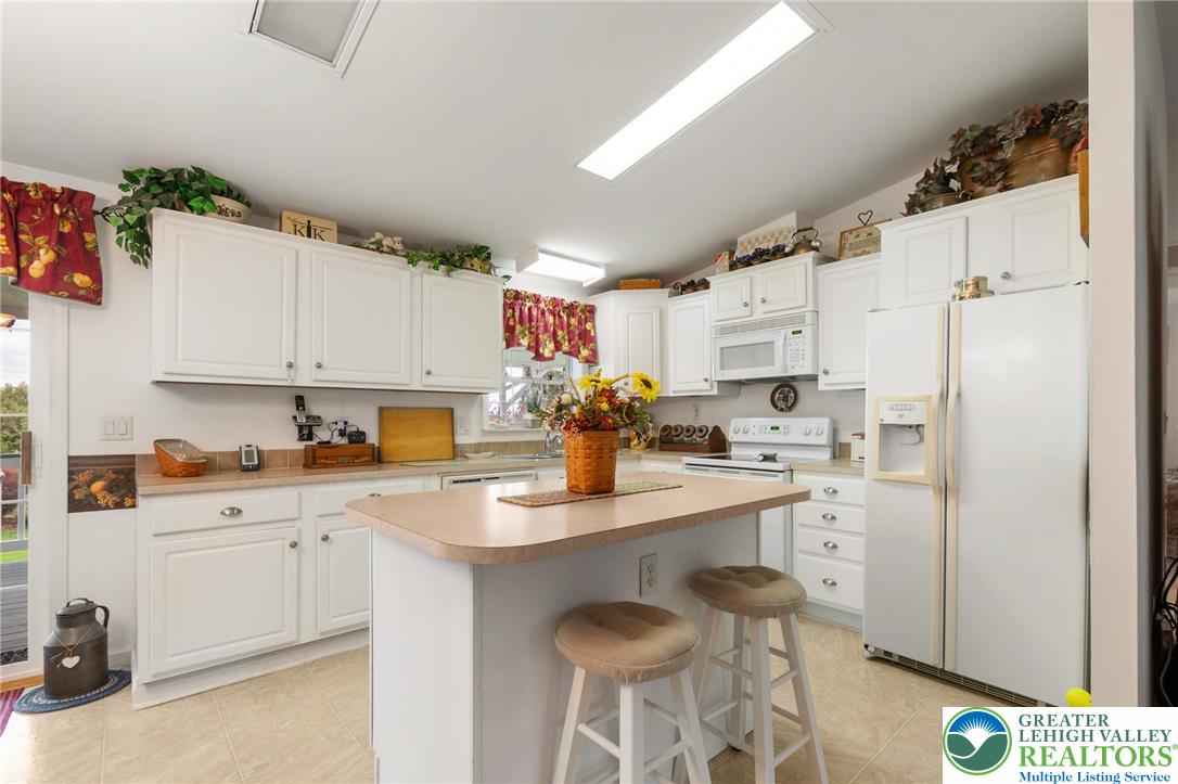 116 Allison Place Blandon, PA 19510 - Photo 6 of 24 a kitchen with white cabinets and white appliances