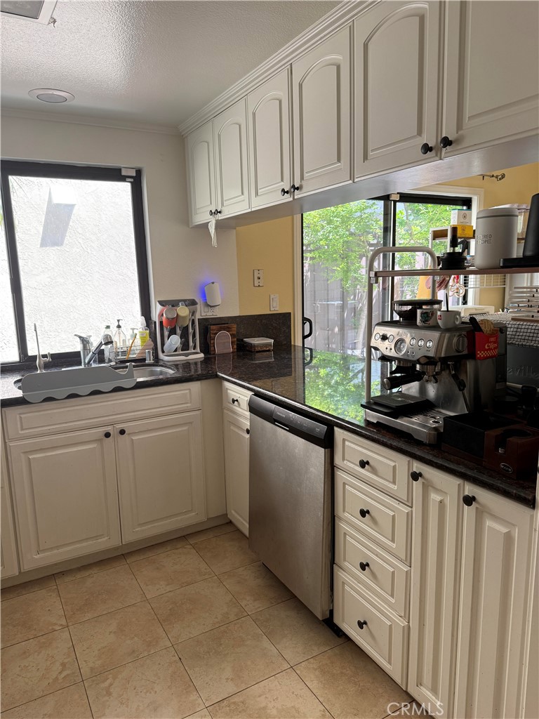 5 Fasano Irvine, CA 92620 - Photo 10 of 10 a kitchen with granite countertop white cabinets and white appliances