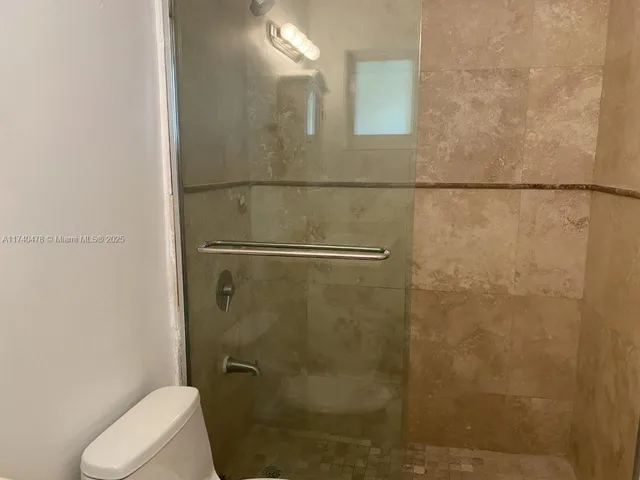 a bathroom with a granite countertop toilet sink and mirror