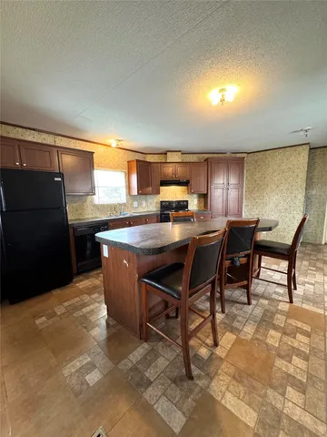a kitchen with a table chairs refrigerator and cabinets