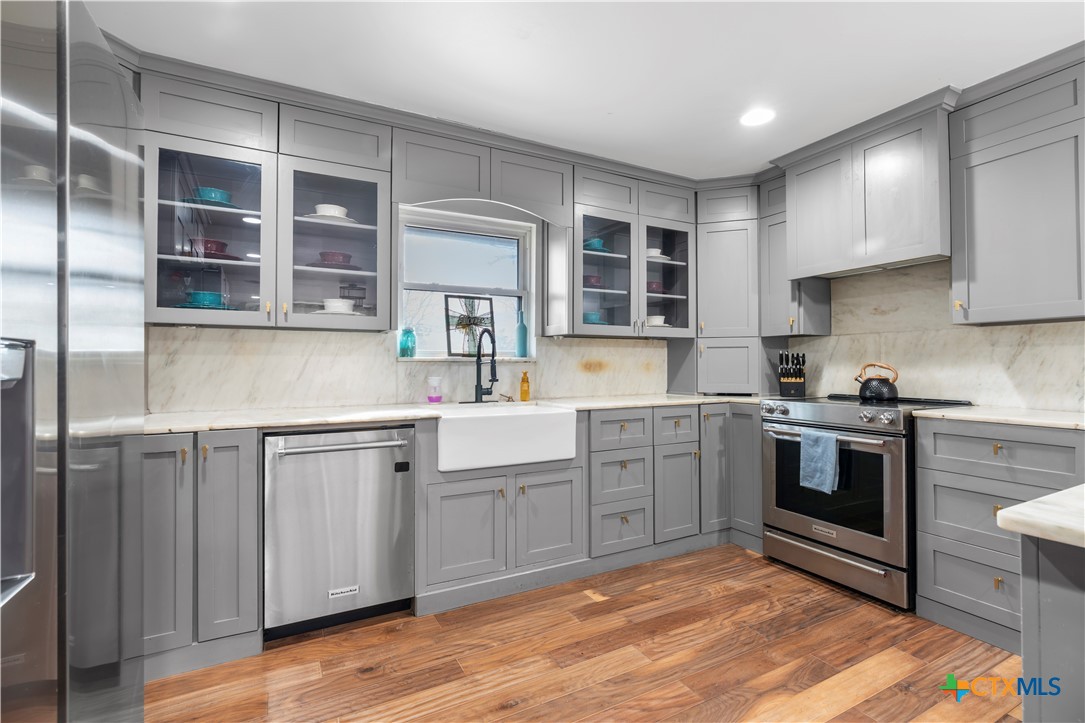308 Liberty Street Gatesville, TX 76528 - Photo 11 of 41 a kitchen with stainless steel appliances granite countertop a stove and cabinets