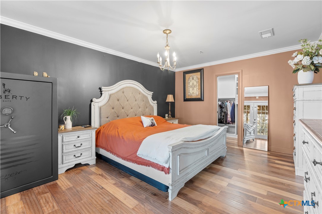 308 Liberty Street Gatesville, TX 76528 - Photo 14 of 41 a bedroom with a large bed and a chandelier