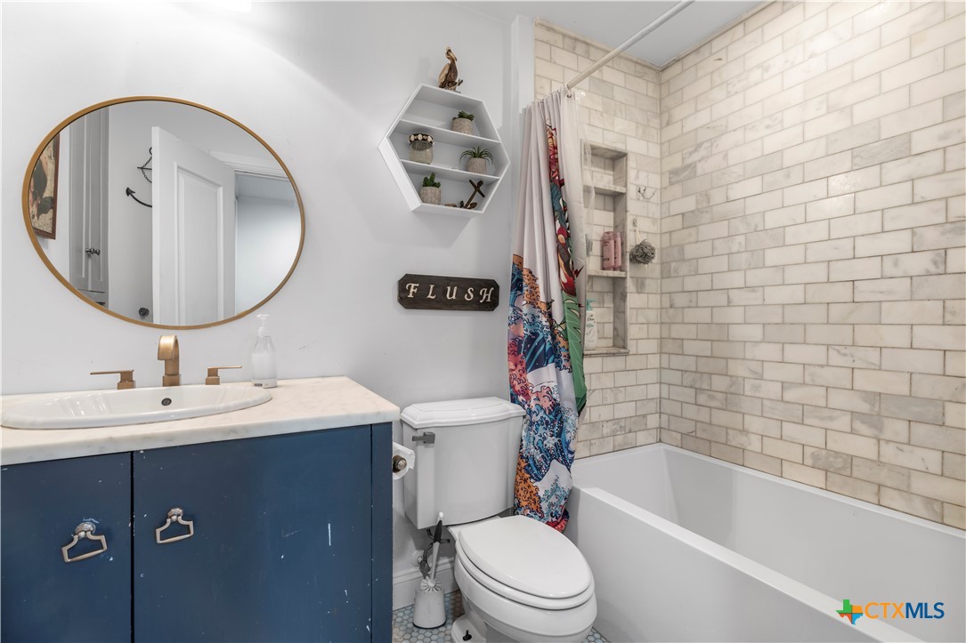 308 Liberty Street Gatesville, TX 76528 - Photo 21 of 41 a bathroom with a toilet a sink a mirror and bathtub