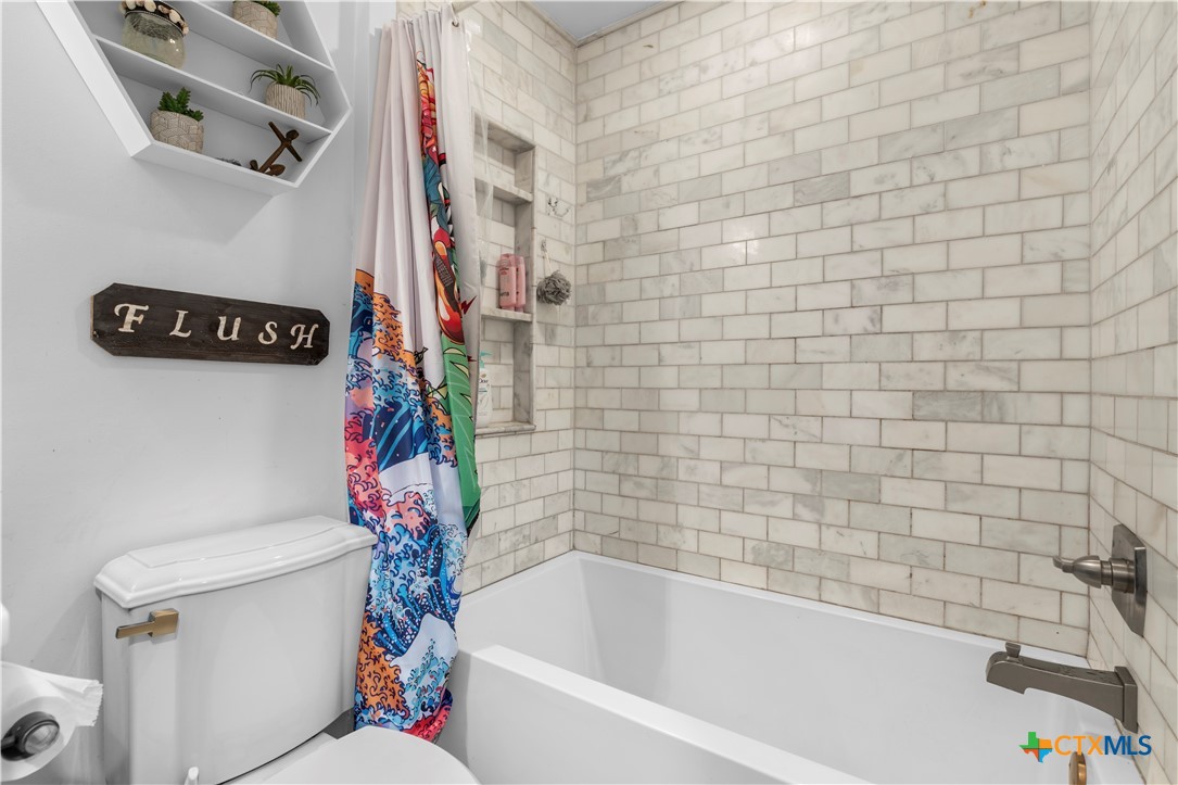 308 Liberty Street Gatesville, TX 76528 - Photo 22 of 41 a white toilet sitting next to a bath tub and a sink