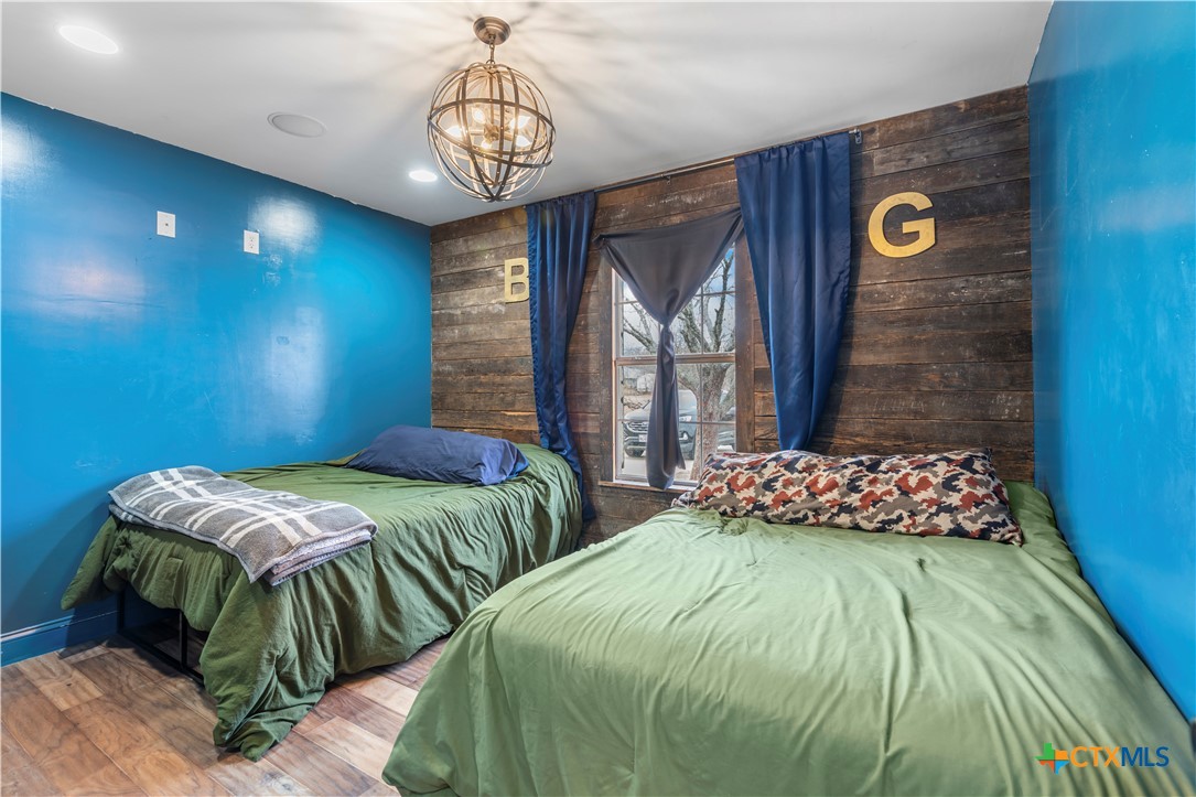 308 Liberty Street Gatesville, TX 76528 - Photo 24 of 41 a bedroom with two beds and a chandelier