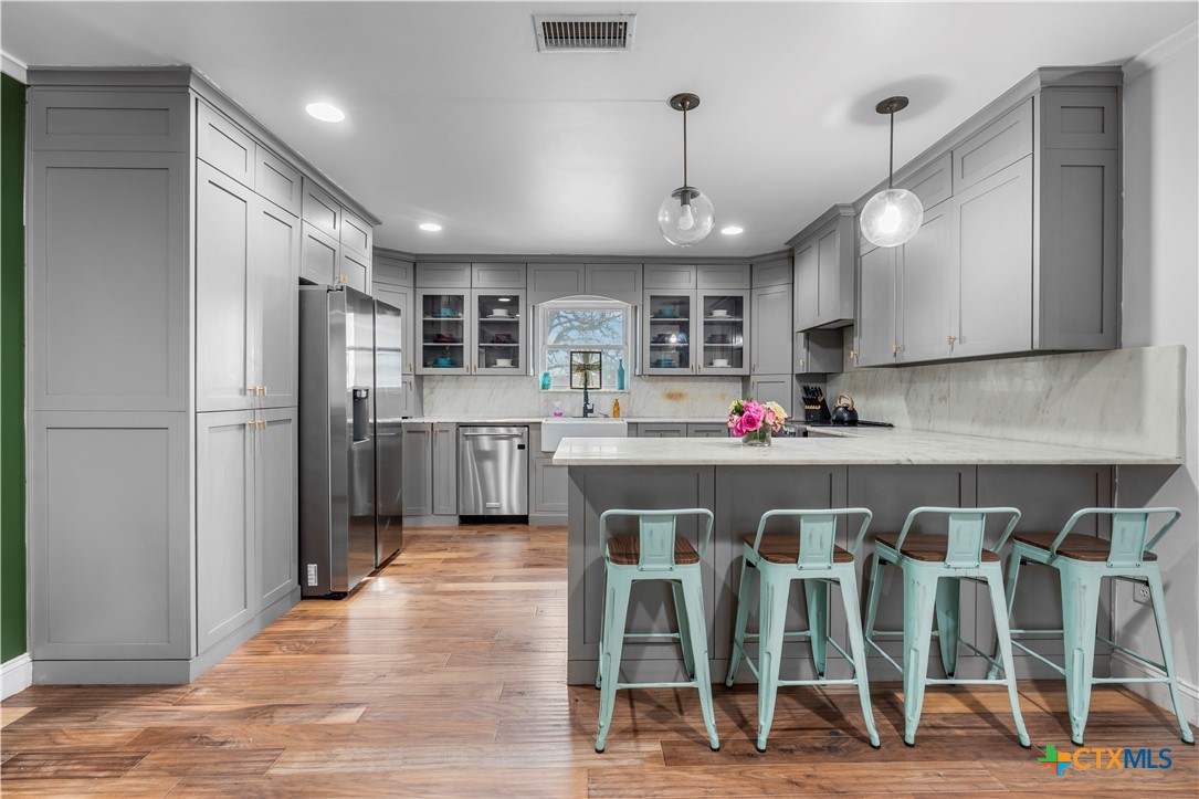 308 Liberty Street Gatesville, TX 76528 - Photo 9 of 41 a large kitchen with white cabinets and stainless steel appliances