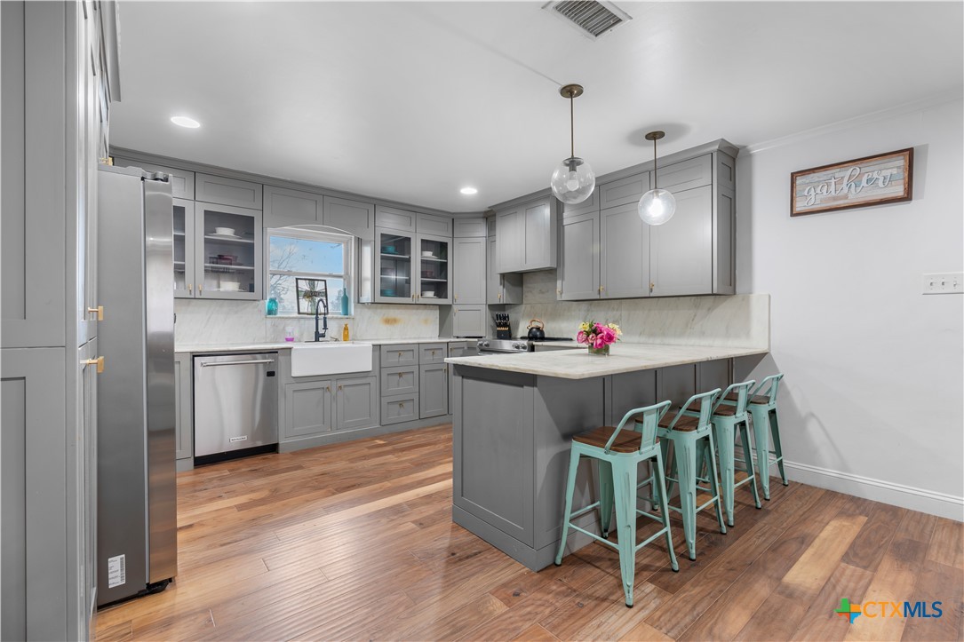 308 Liberty Street Gatesville, TX 76528 - Photo 10 of 41 a kitchen with stainless steel appliances granite countertop a table chairs sink and cabinets