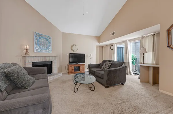 a living room with furniture a fireplace and a flat screen tv