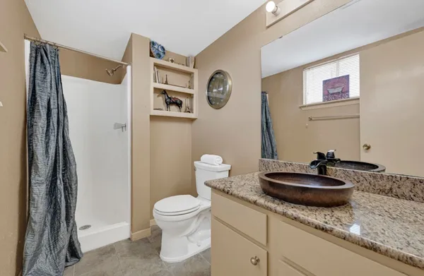 a bathroom with a granite countertop toilet and a sink