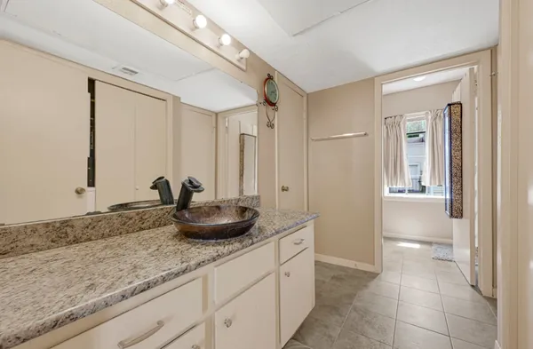 a bathroom with a granite countertop sink a toilet and a mirror