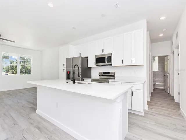 a kitchen with a refrigerator and a wooden floor