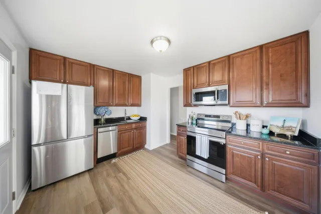 a kitchen with stainless steel appliances granite countertop a refrigerator stove top oven and sink