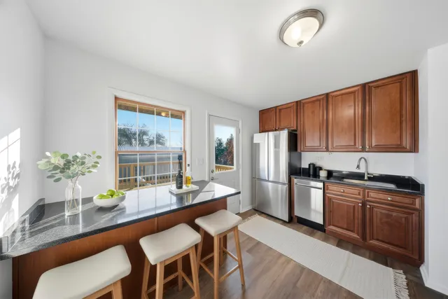 a kitchen with granite countertop sink table and chairs