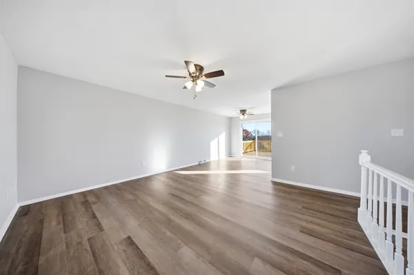 a living room with furniture or chandelier and a wooden floor