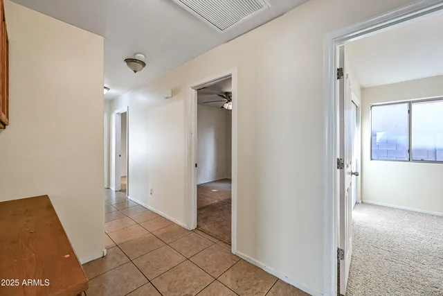 a view of a hallway with closet and bathroom