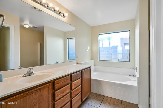 a bathroom with a tub a sink and a mirror