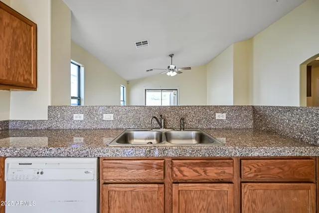 a kitchen with granite countertop a sink and cabinets