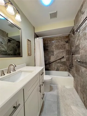 a bathroom with a sink mirror toilet and bathtub