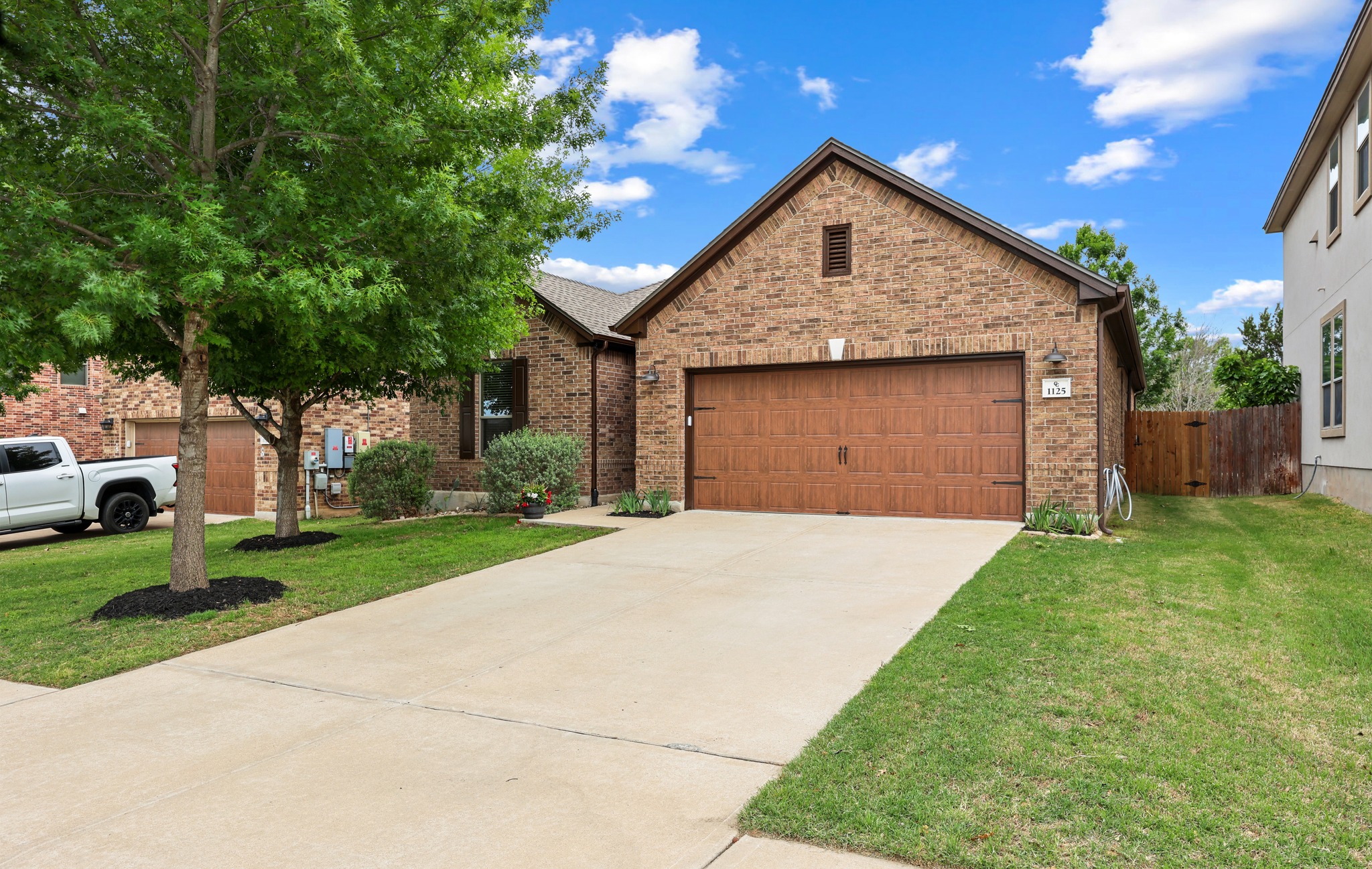 1125 Yellow Iris Road Leander, TX 78641 - Photo 2 of 31 View of front facade featuring a garage, driveway, and brick siding