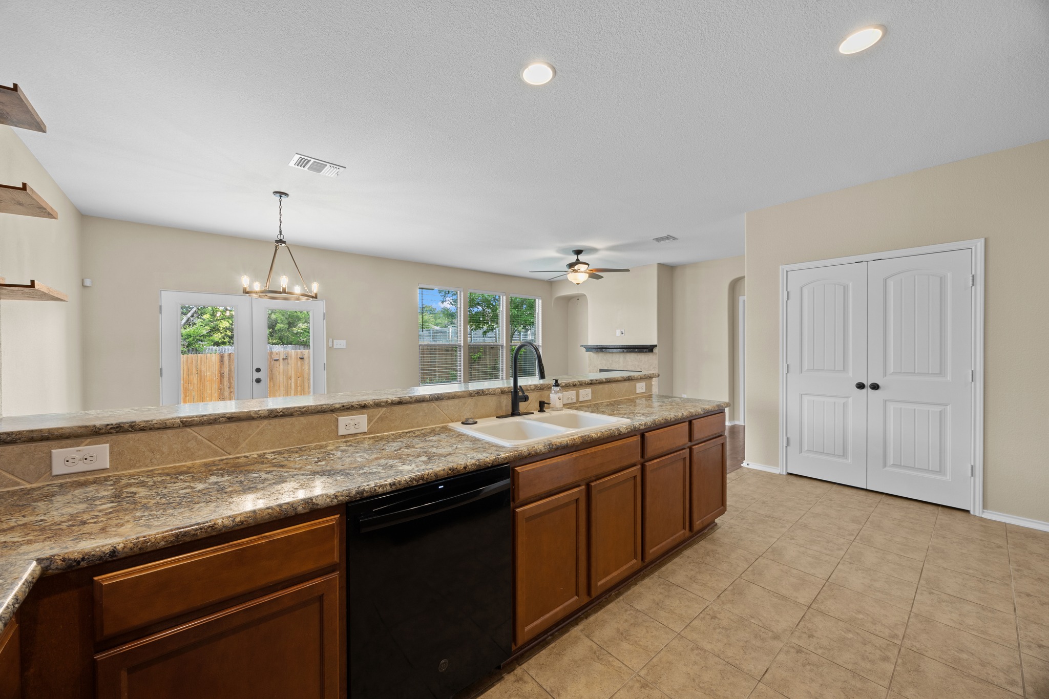 1125 Yellow Iris Road Leander, TX 78641 - Photo 21 of 31 Kitchen featuring suspended lighting, dishwasher, a ceiling fan, arched walkways, and wood finish cabinets