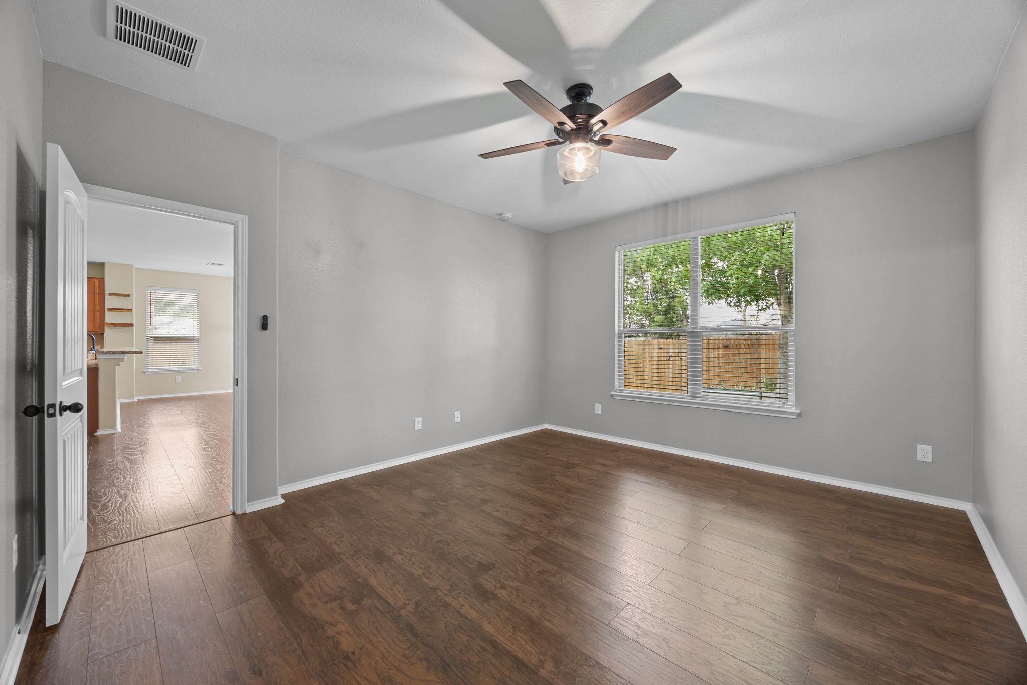1125 Yellow Iris Road Leander, TX 78641 - Photo 23 of 31 Unfurnished bedroom with dark wood-style floors, healthy amount of natural light, and ceiling fan