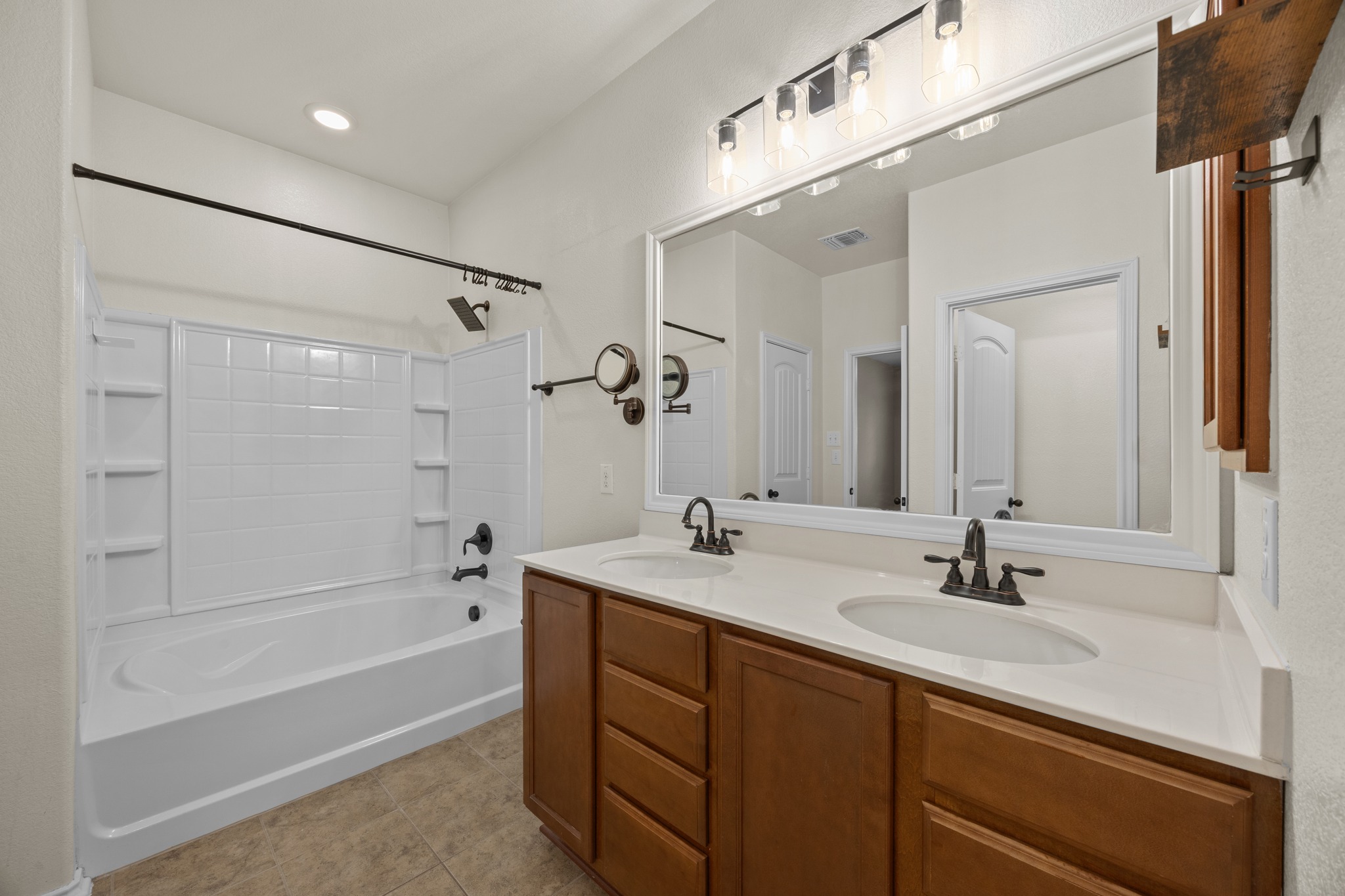1125 Yellow Iris Road Leander, TX 78641 - Photo 26 of 31 Bathroom with double vanity, shower / bathtub combination, and light tile patterned floors