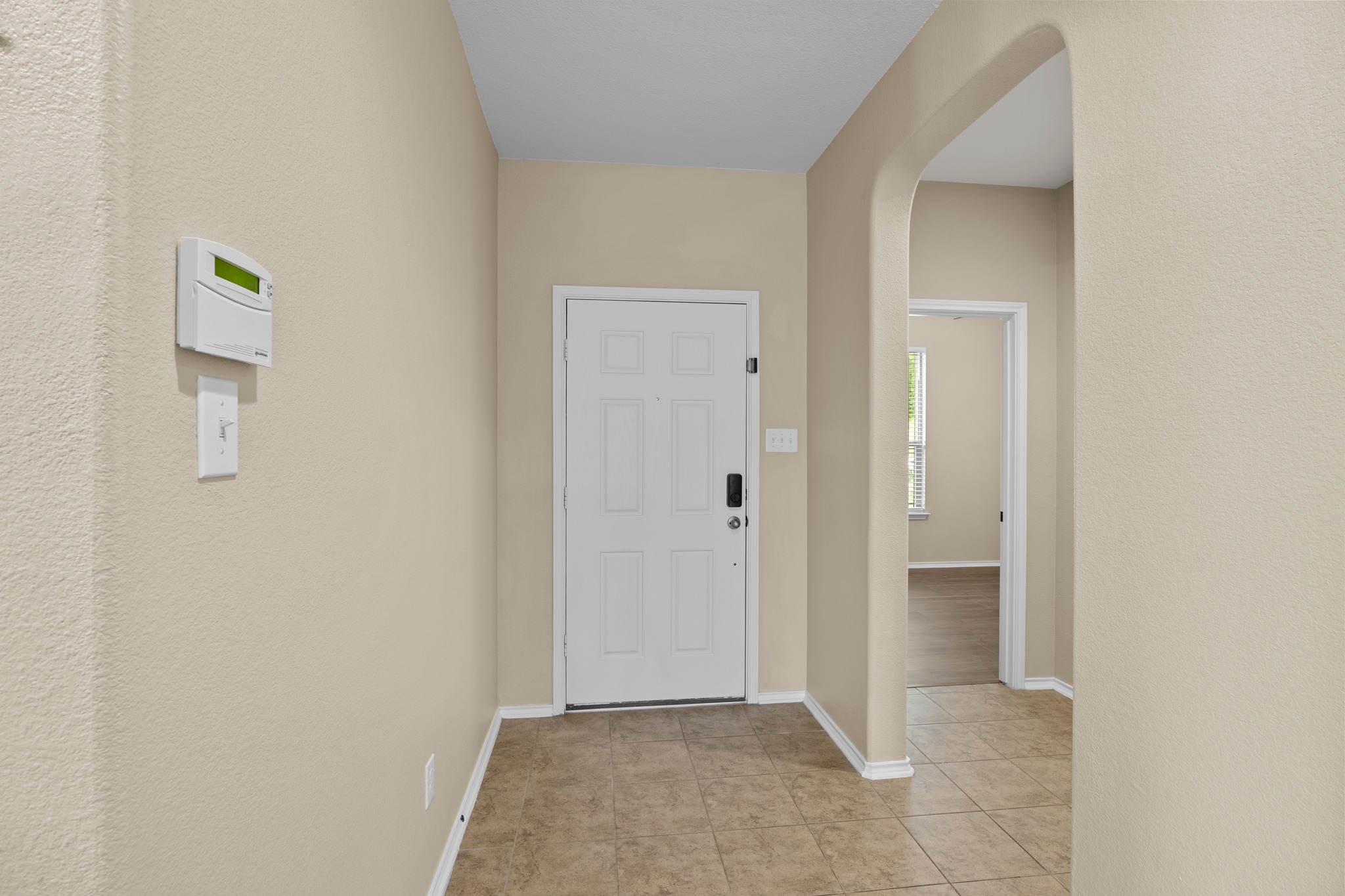 1125 Yellow Iris Road Leander, TX 78641 - Photo 4 of 31 Foyer entrance with arched walkways, light tile patterned floors, and a textured wall