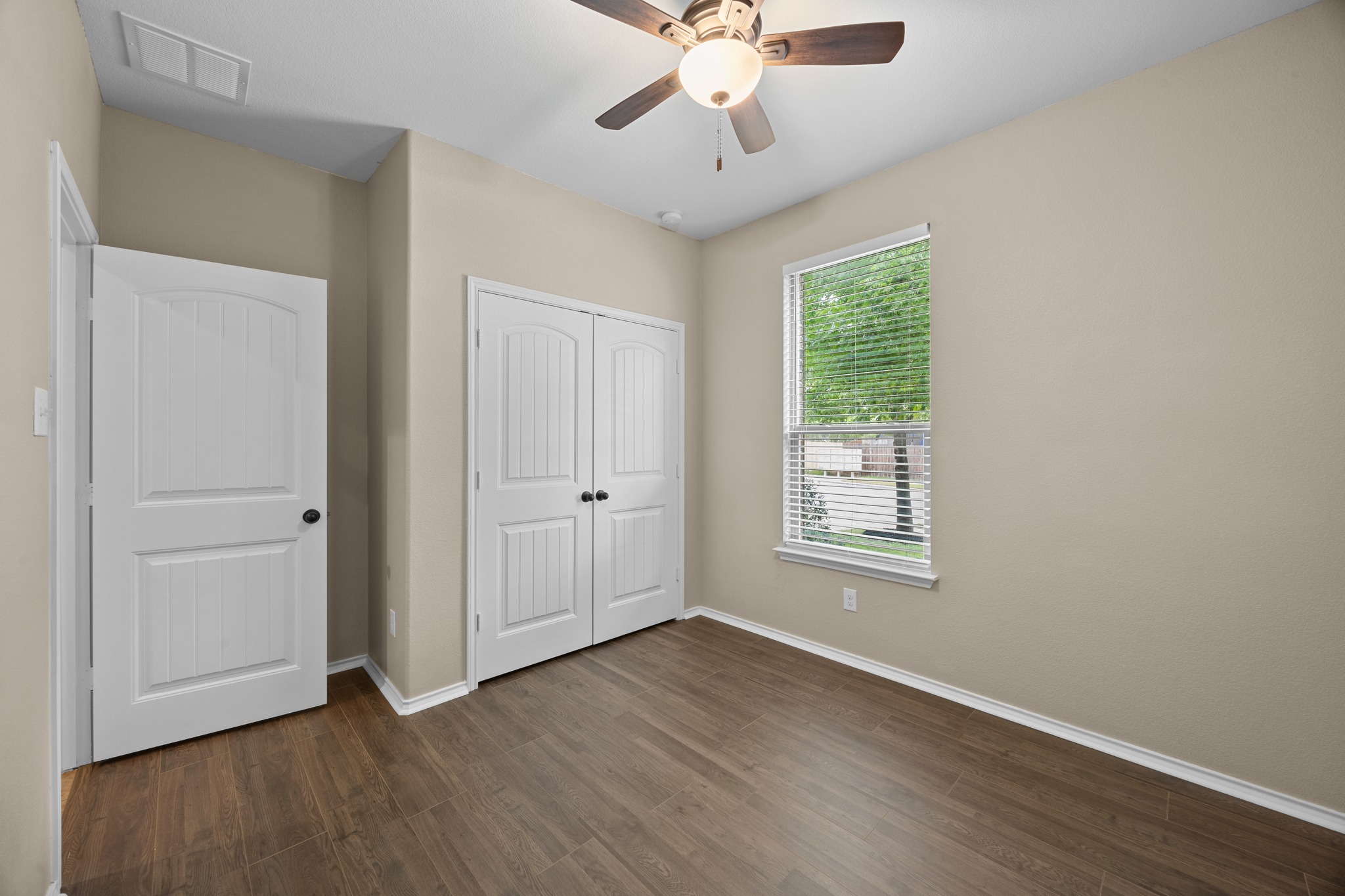 1125 Yellow Iris Road Leander, TX 78641 - Photo 6 of 31 Unfurnished bedroom featuring dark wood-style flooring, a ceiling fan, and a closet