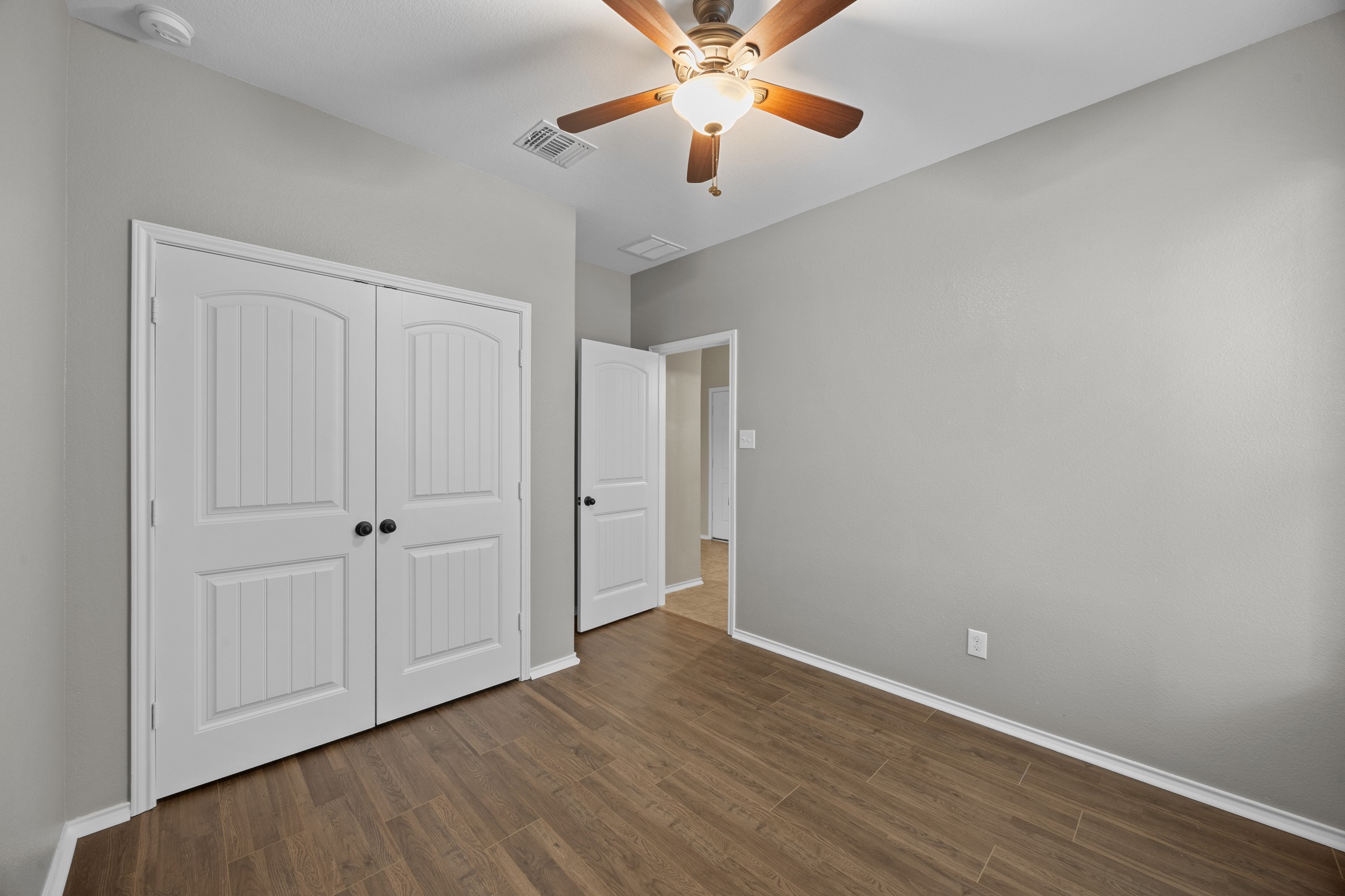 1125 Yellow Iris Road Leander, TX 78641 - Photo 8 of 31 Unfurnished bedroom featuring dark wood finished floors, ceiling fan, and a closet