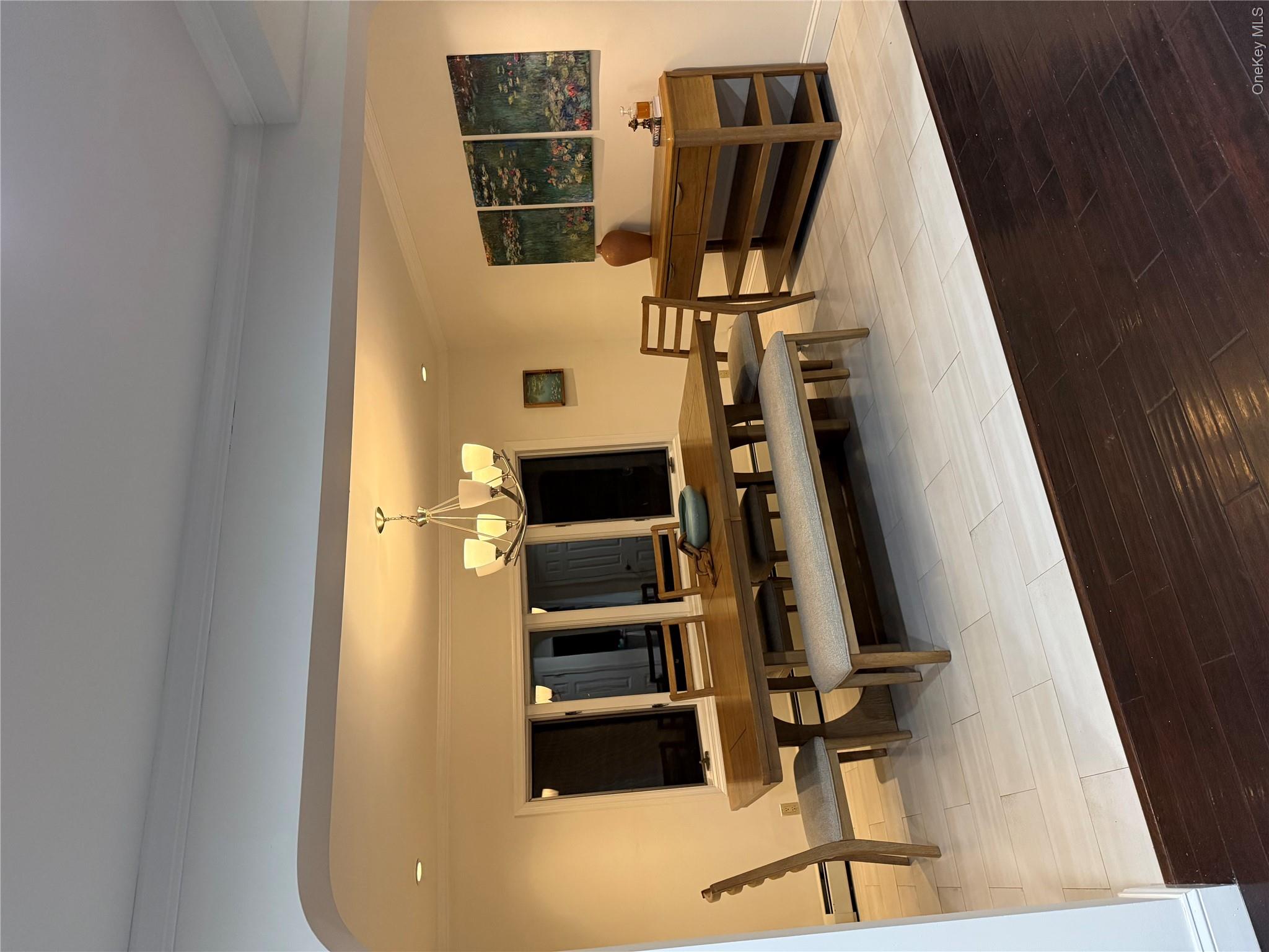 29 Wilton Road Rye Brook, NY 10573 - Photo 2 of 18 Dining room with a notable chandelier, ornamental molding, arched walkways, light wood finished floors, and baseboards