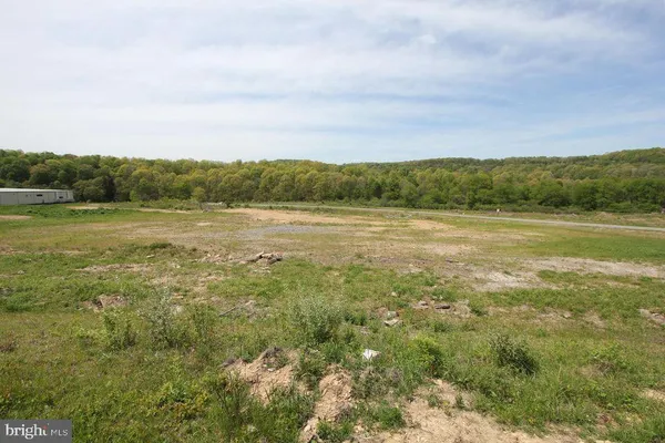 a view of a field with mountains in the background