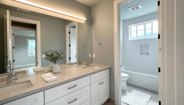 a bathroom with a granite countertop sink mirror and toilet