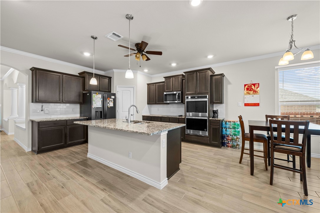 1305 Roma Street Harker Heights, TX 76548 - Photo 5 of 28 a kitchen with stainless steel appliances kitchen island granite countertop a table chairs and a refrigerator