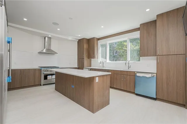 a kitchen with stainless steel appliances granite countertop a stove a sink and a refrigerator